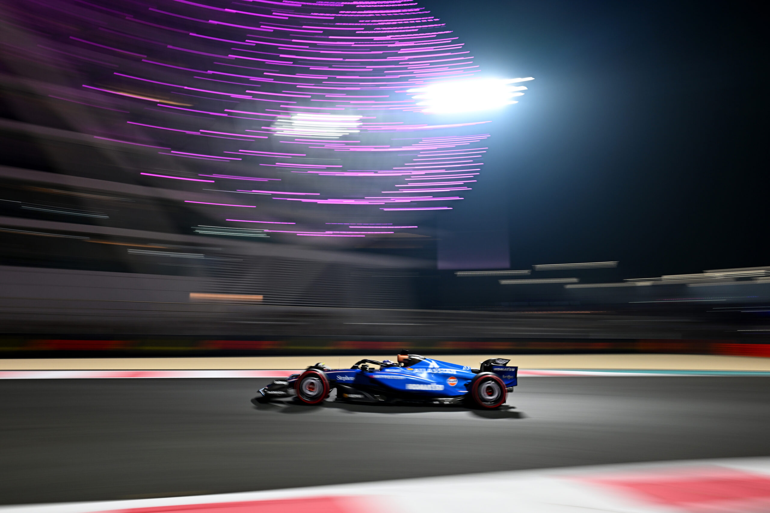Alex Albon's Williams passing under the lights at Yas Marina. He finished 16th at the 2025 F1 Abu Dhabi GP