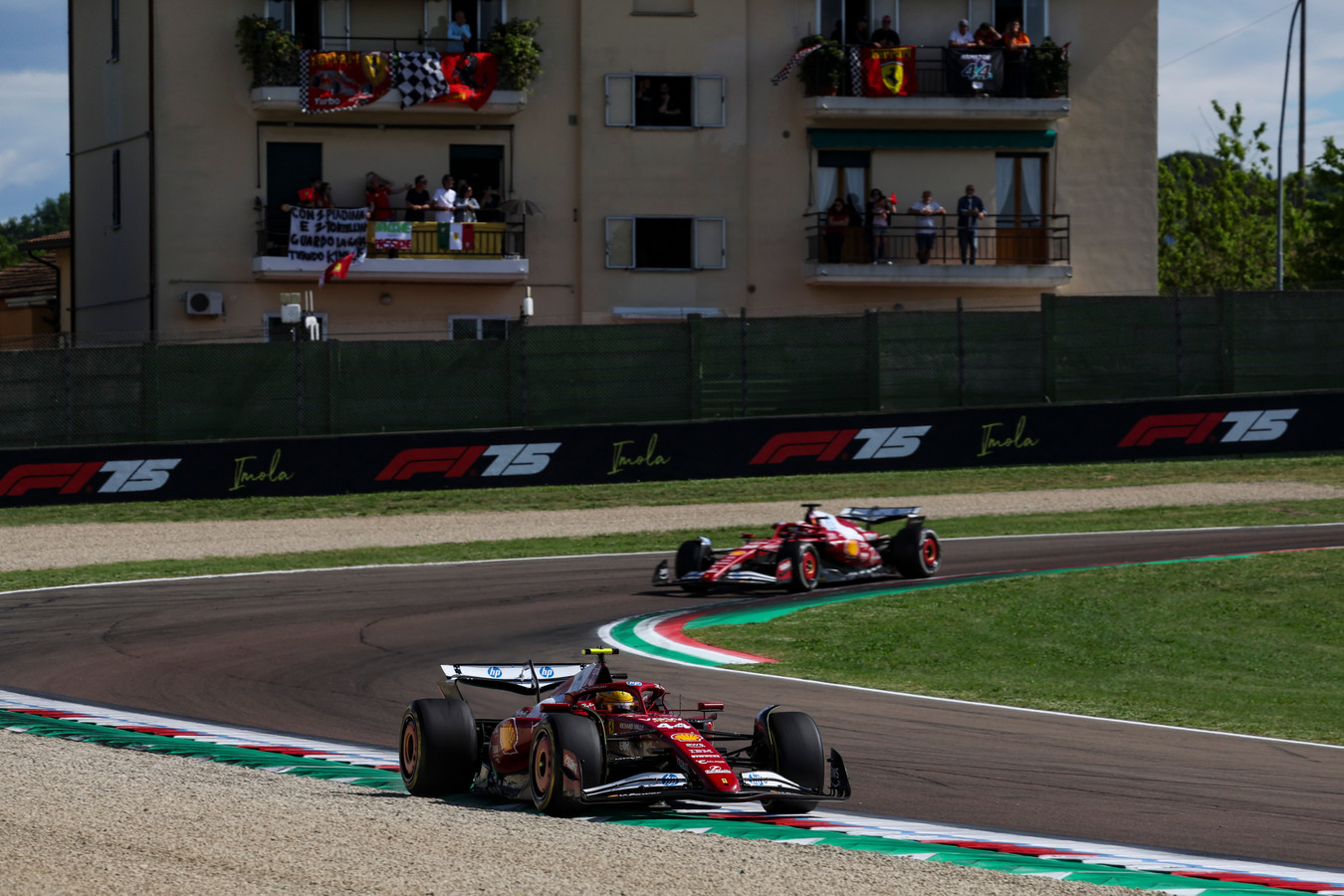 Ferraris passing by a house overlooking the Emilia Romagna Grand Prix