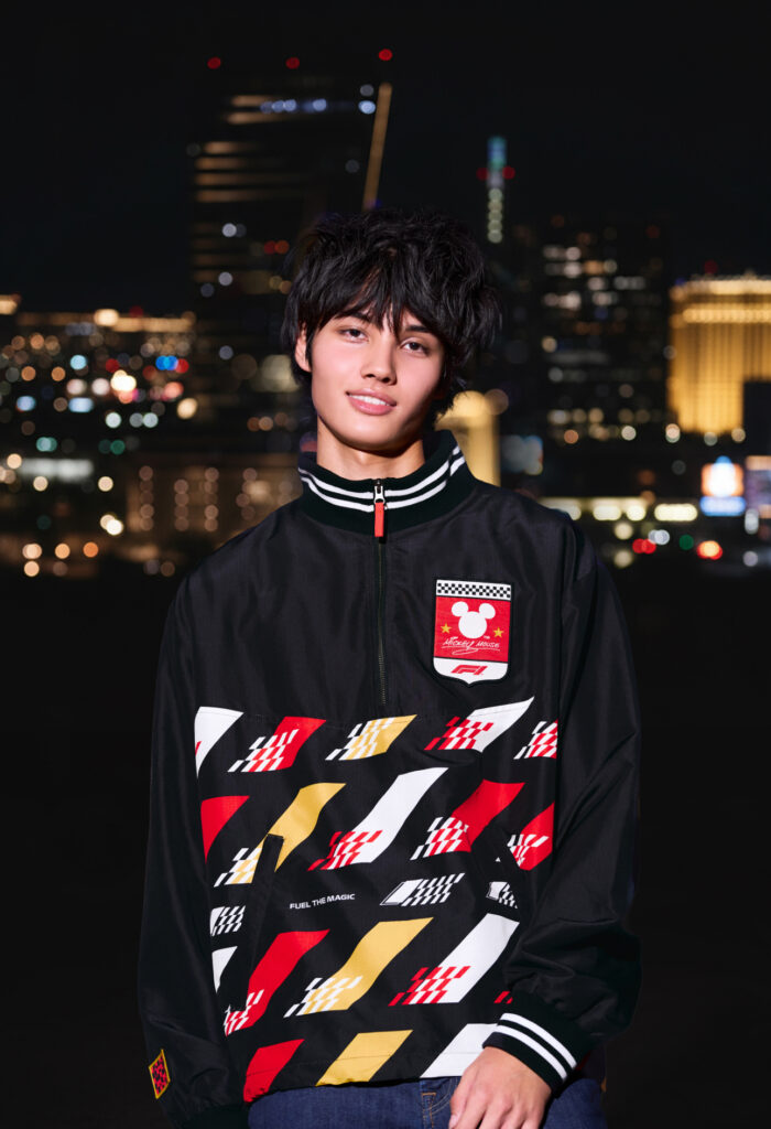 A male model wearing F1 x Disney merchandise sweater