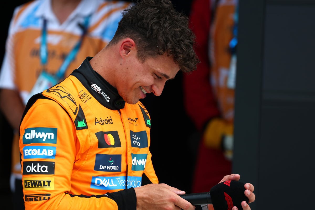 Lando Norris of McLaren Racing looking down at a microphone by F1