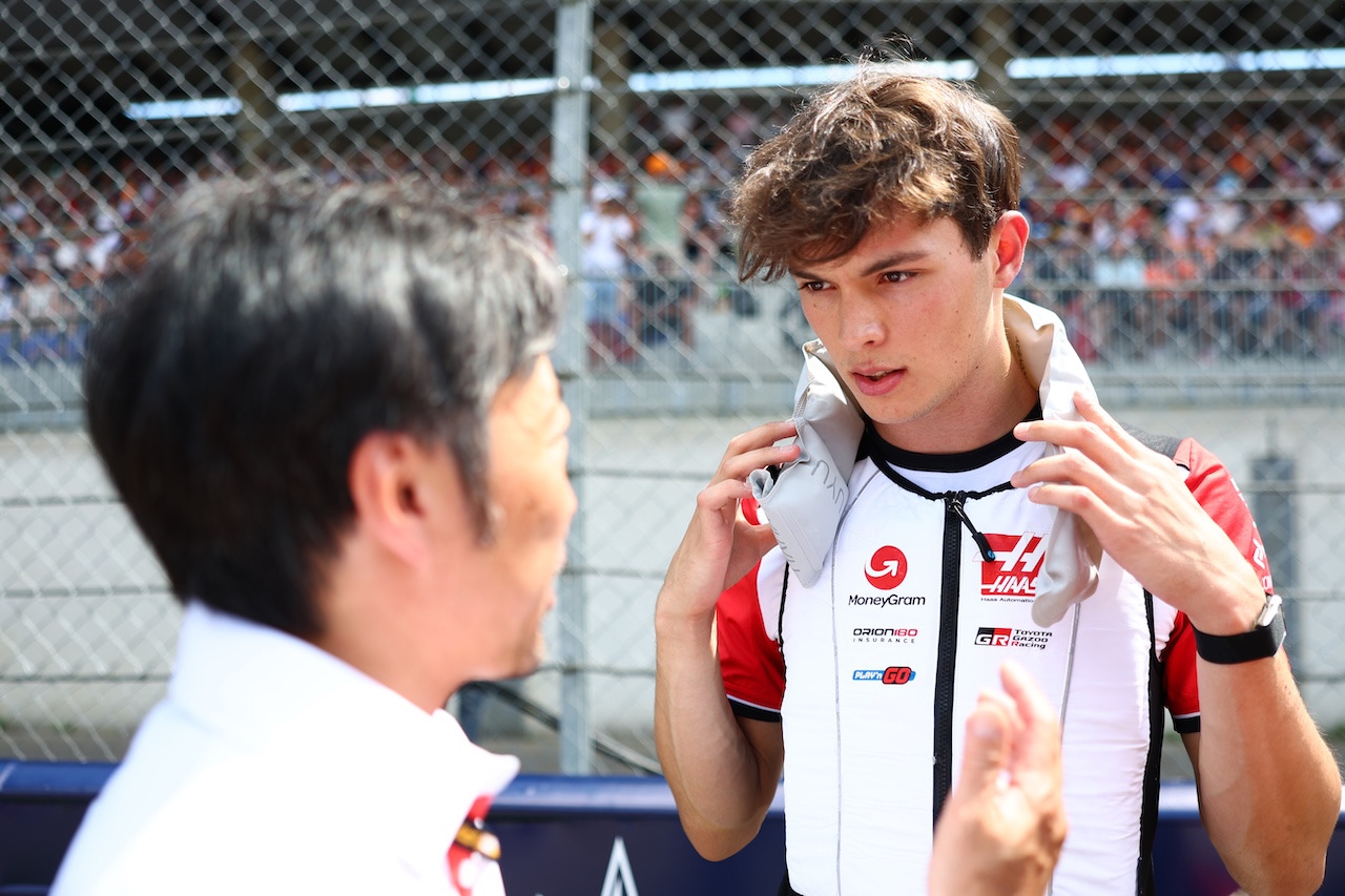 SPIELBERG, AUSTRIA - JUNE 29: Oliver Bearman of Great Britain and Haas F1 talks with Ayao Komatsu, Team Principal of Haas F1 on the grid prior to the F1 Grand Prix of Austria at Red Bull Ring on June 29, 2025 in Spielberg, Austria. (Photo by Peter Fox/LAT Images)
