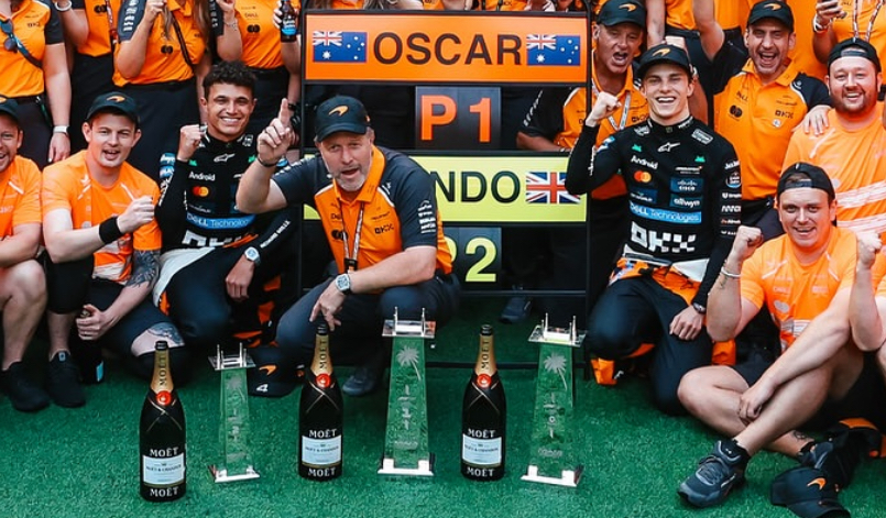 A section of McLaren's post race Miami GP victory team photo showing key personnel including Piastri, Norris, Stella and Brown.