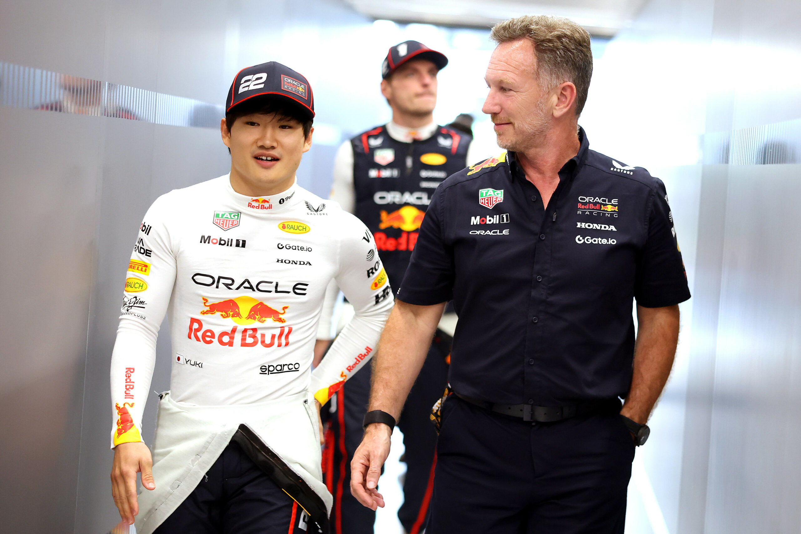 Red Bull Team Principal Chrsitian Horner walking alongside Tsunoda with Verstappen in the background, in Jeddah, Saudi Arabia GP
