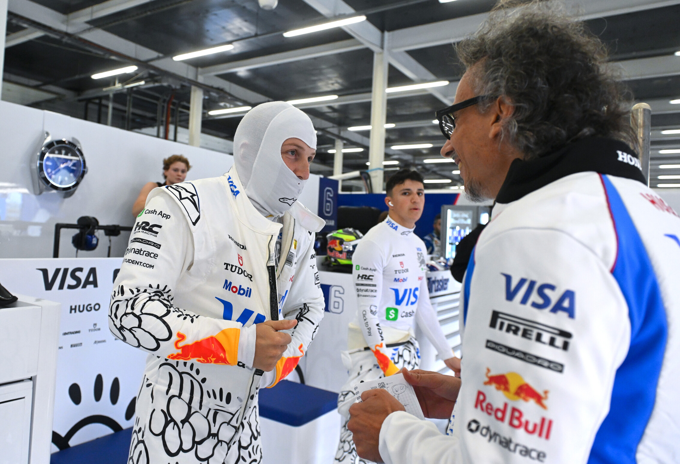Racing Bulls drivers Liam Lawson and Isack Hadjar in the garage with team principal Laurent Mekies during the F1 British GP 2025