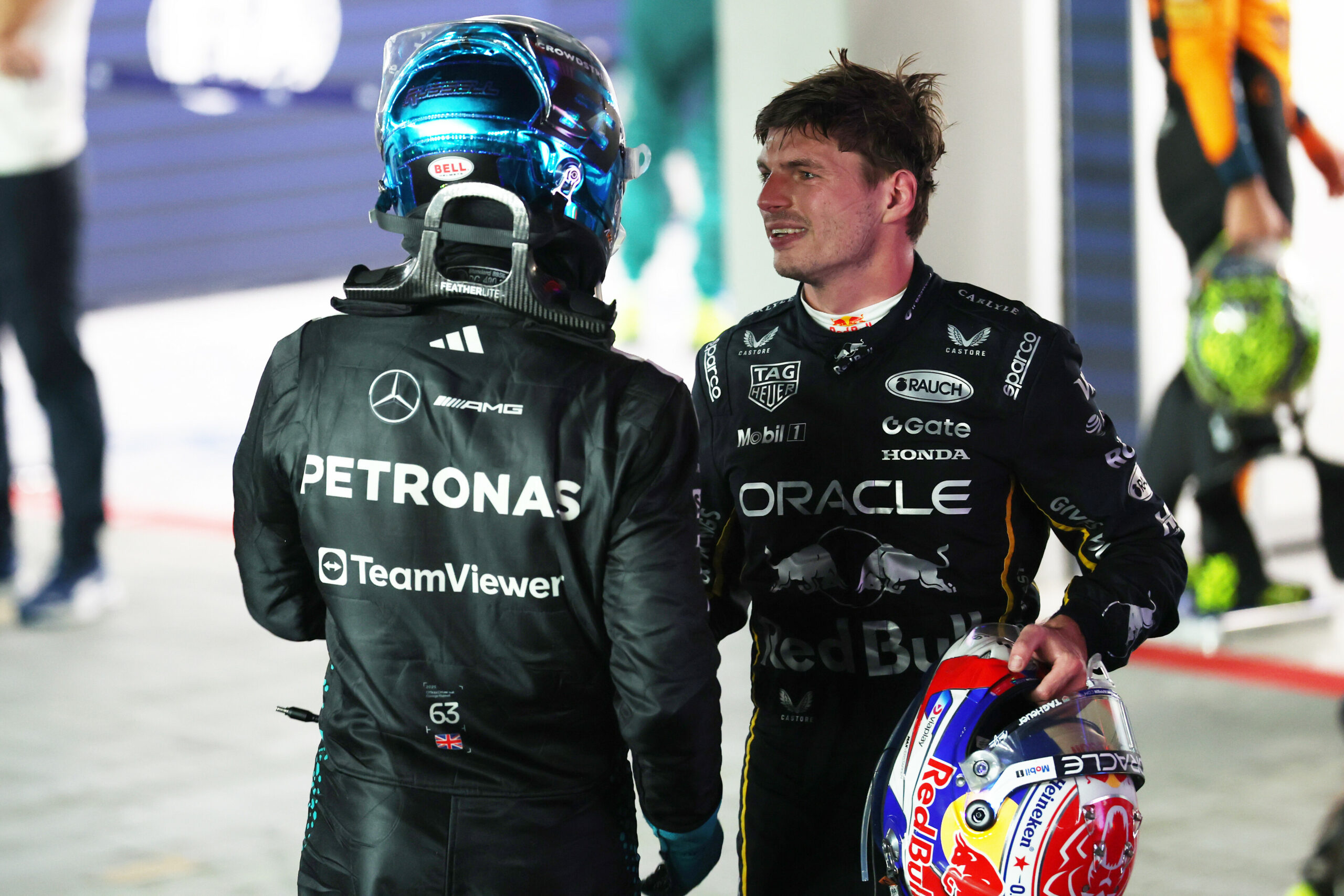 Max Verstappen and George Russell shaking hands after the F1 Singapore GP, the two currently in a battle for P3 in the Championship.