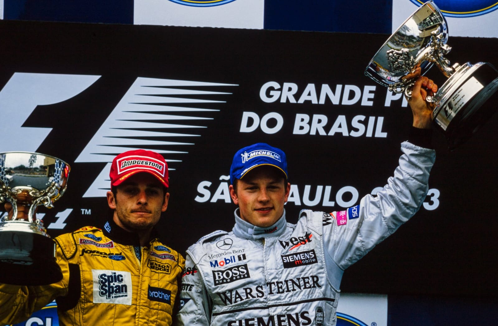 Kimi Räikkönen and Giancarlo Fisichella celebrate as the only two drivers on the podium after the 2003 F1 Brazilian Grand Prix in Jordan F1's final victory