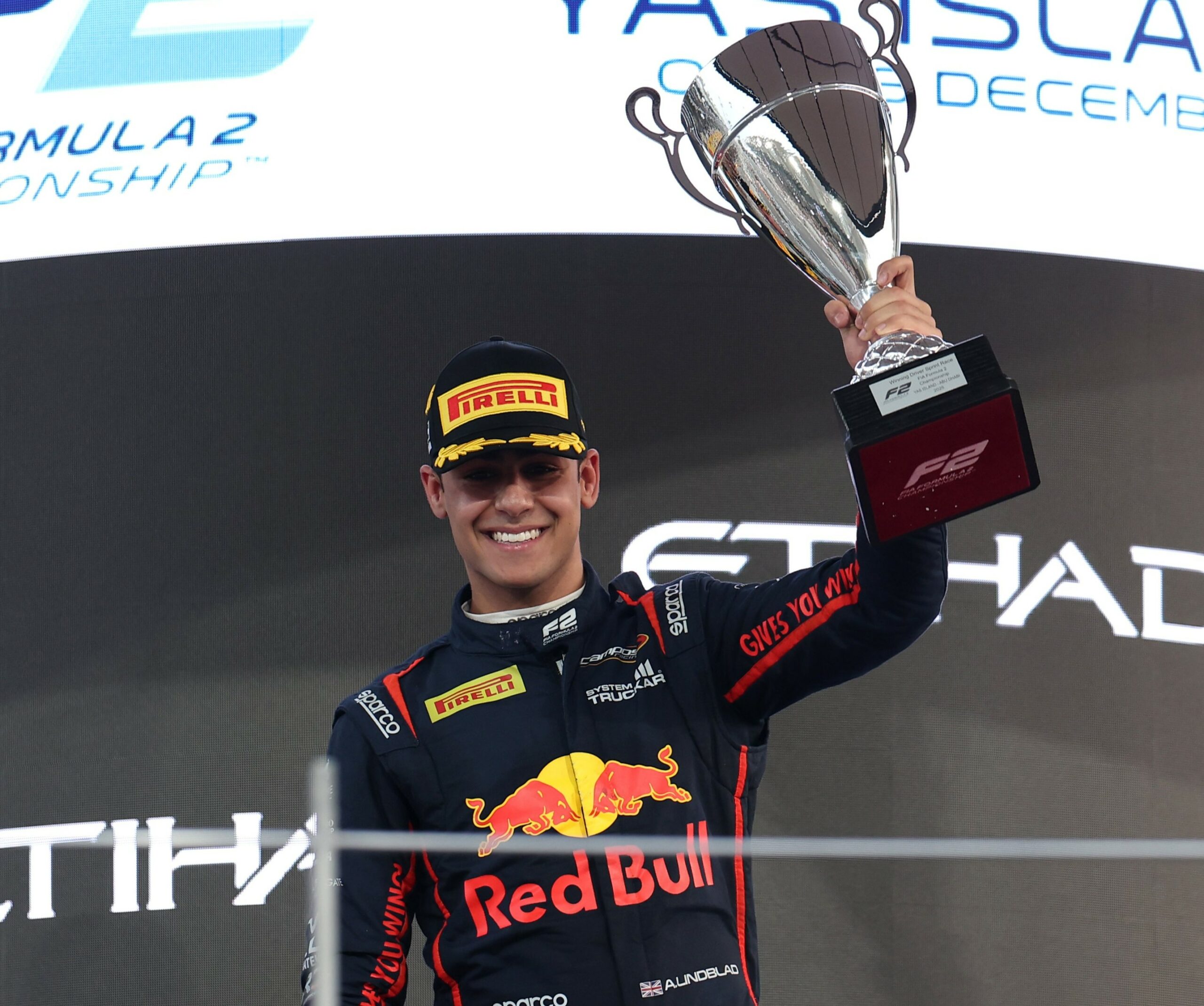 Campos Racing's Arvid Lindblad on the podium celebrating his P1 finish in the 2025 F2 Abu Dhabi GP Sprint Race.