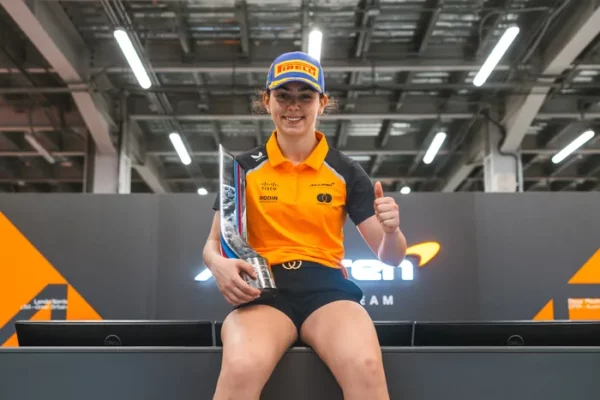 F1 Academy driver Ella Lloyd sitting in the McLaren Garage. 2025
